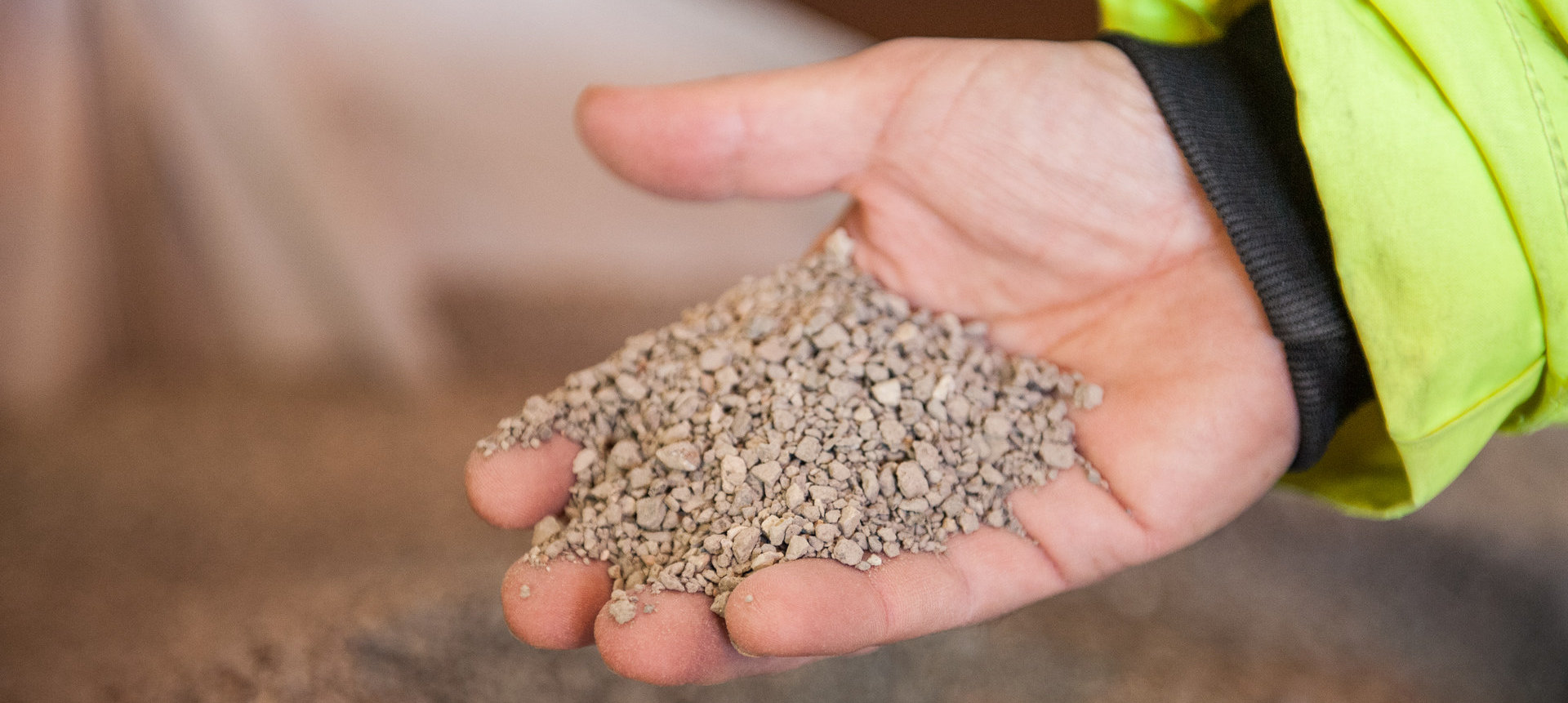 Close-up of bentonite being poured from hand during product quality check