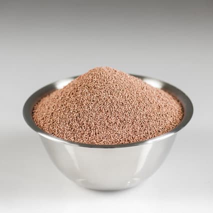 Bowl of fine-grained calcined diatomaceous earth with warm earthy tones, used in filtration and absorbent mineral products