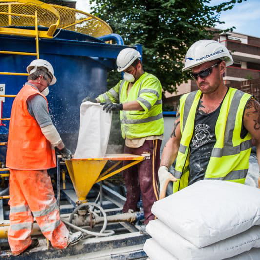 Workers mixing bentonite powder to create drilling fluid for civil engineering project